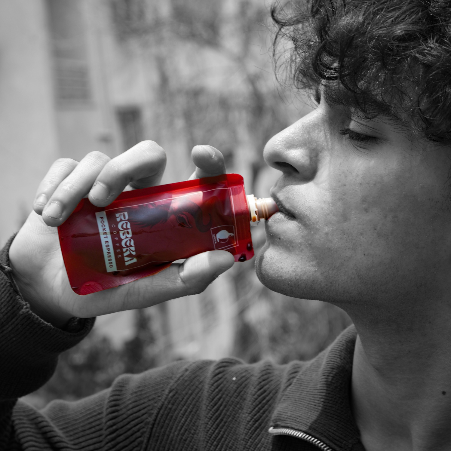 Close-up of a man's hands holding pocket espresso, slurping his heads tilted upwards.